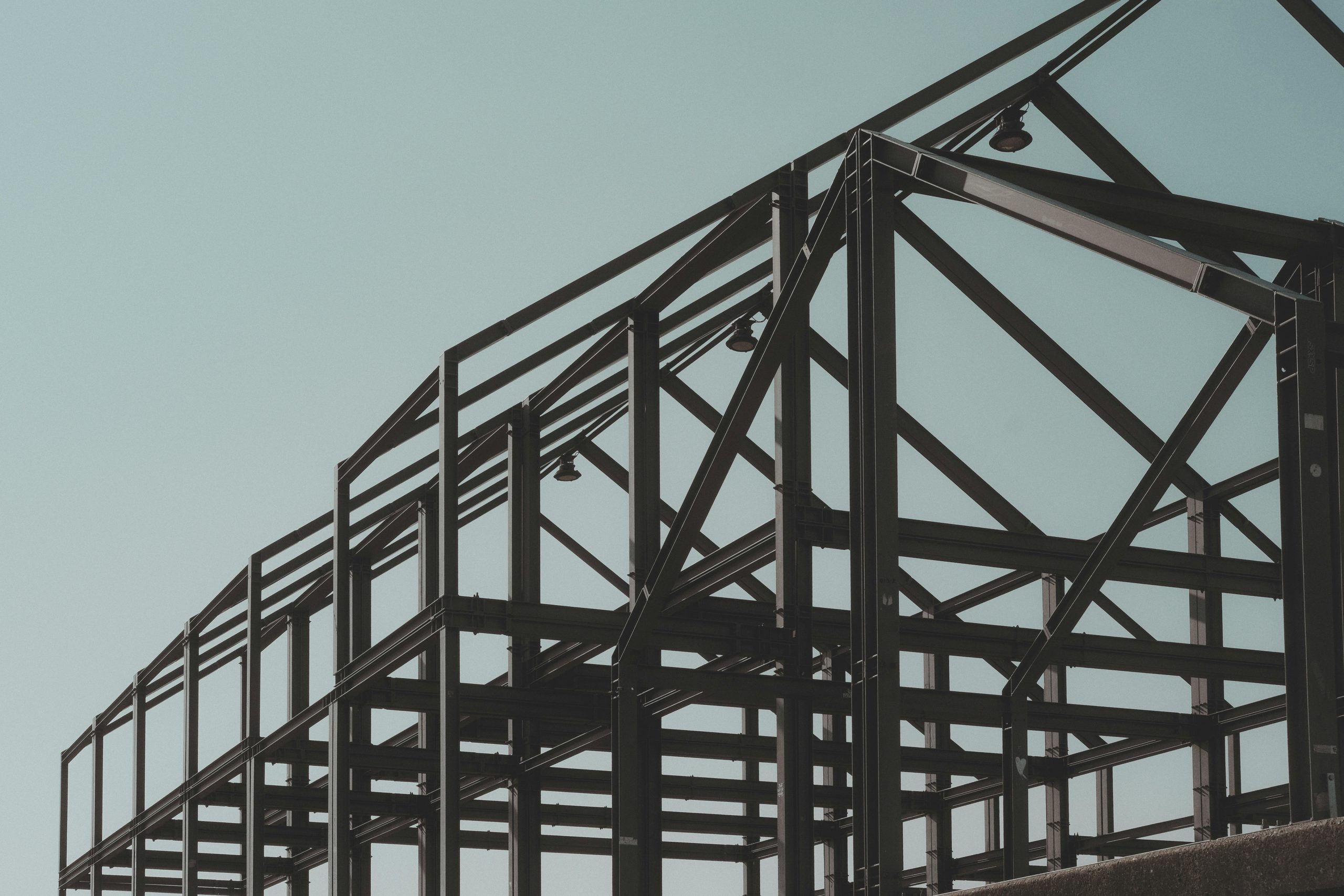 Modern steel framework structure under clear sky, showcasing architectural design.